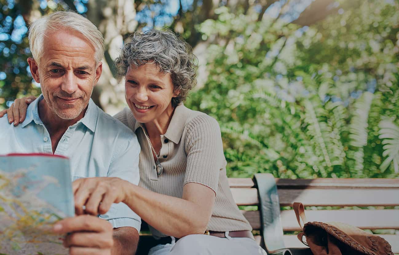 happy older couple looking at a map